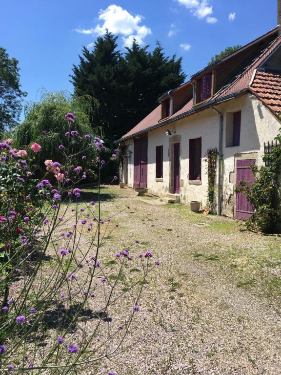 MontipouretGîte Les Tazons - Pays de George Sand的一座古房子,前面有紫色的鲜花