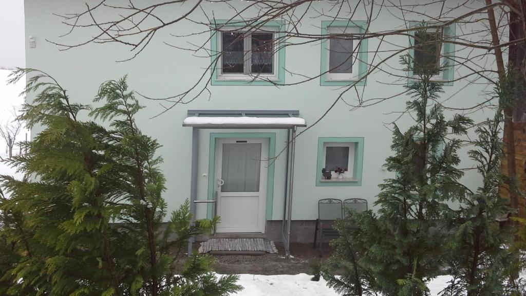 阿尔高内的伊门施塔特Haus Bergpanorama的白色的房子,有蓝色的门和树木