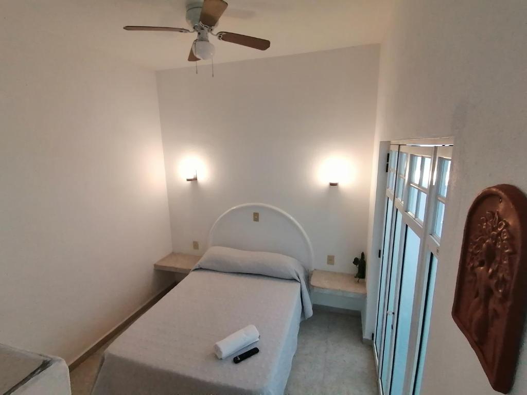 科利马Htl & Suites Neruda, ubicación, limpieza, facturamos的一间带一张床和吊扇的小卧室