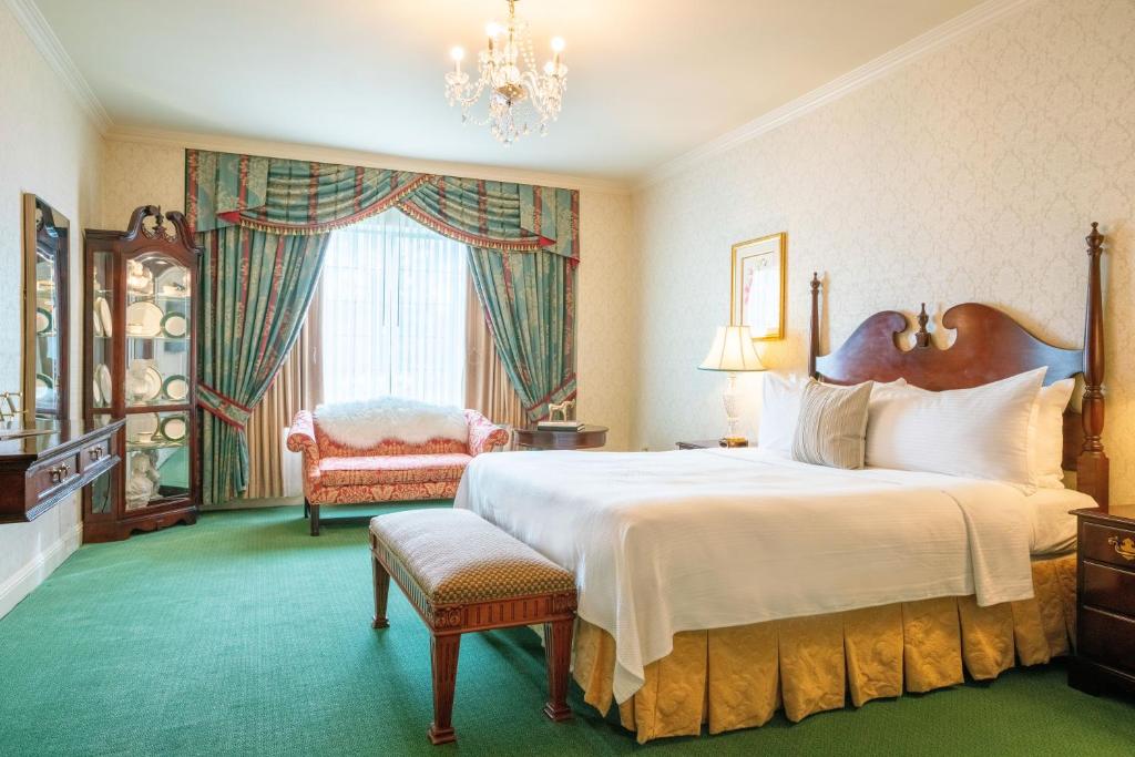 坎贝尔The Bristol Hotel Campbell San Jose的卧室配有一张白色大床和一把椅子