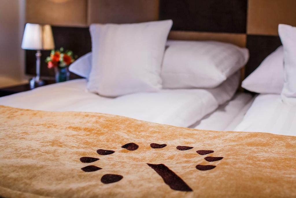 罗兹II号精品酒店的一张带毯子和狗爪图案的床