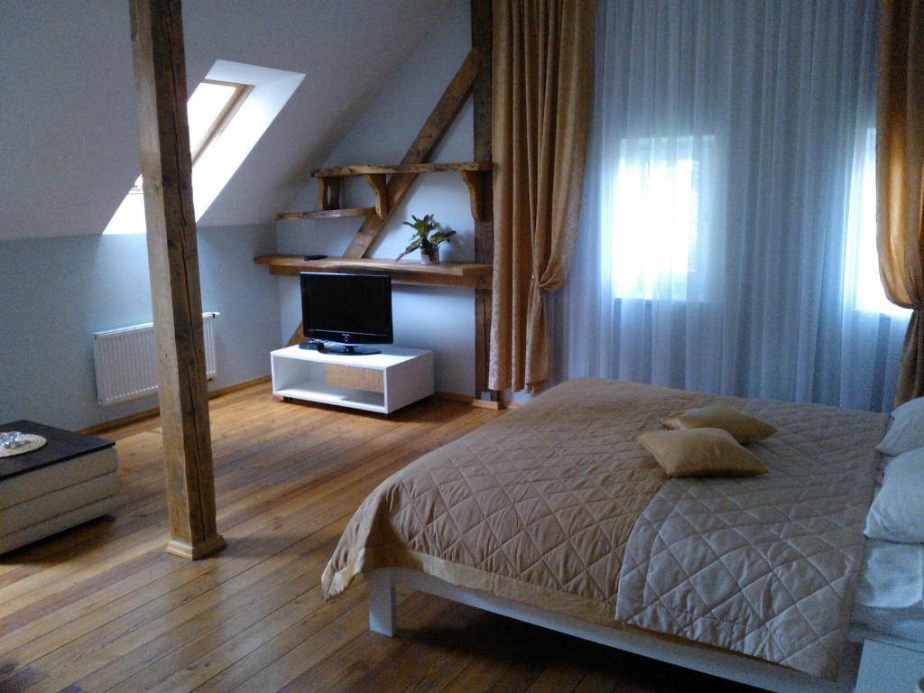 希卢泰Miško Apartments的一间卧室配有一张床和一台电视