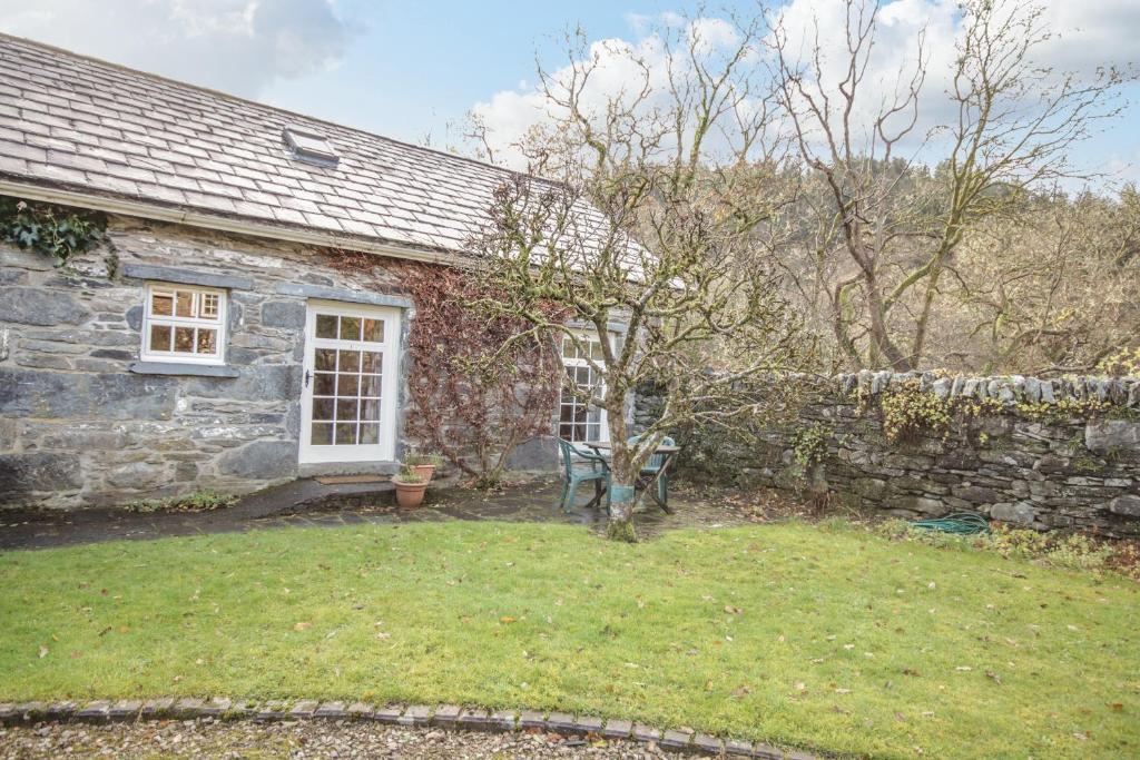 贝图瑟科伊德Royal Oak Farm Cottage的一座石头房子,设有花园和石墙