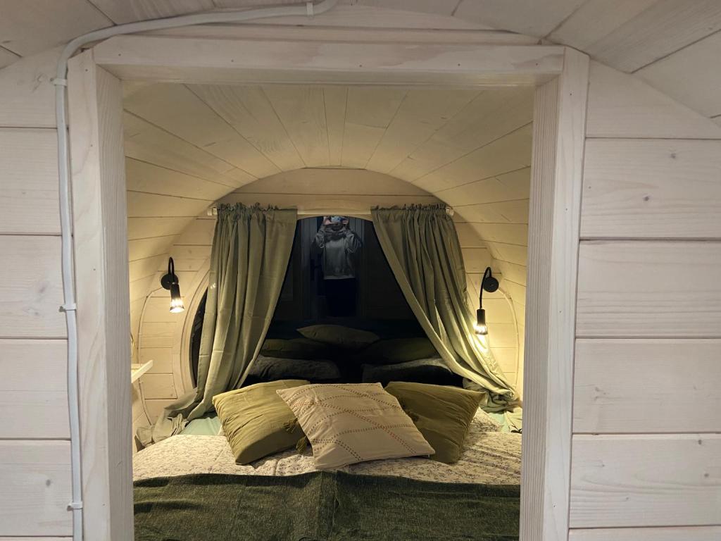 TrzemeśniaBeczki Pod Lasem的配有窗帘的小房间中的一张床位