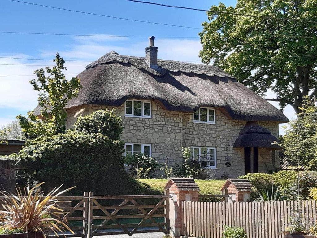 沃明斯特Kings Cottage - Heart of the Deverills的一座带茅草屋顶的大型石屋