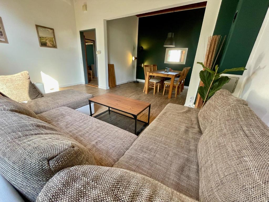 不来梅港Bettchen - Helle charmante Wohnung mit Hochebene的客厅配有沙发和桌子