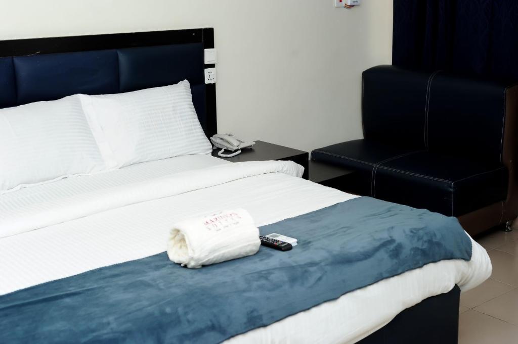 拉各斯Mariners Suites Lagos的一张带毛巾的床和遥控器