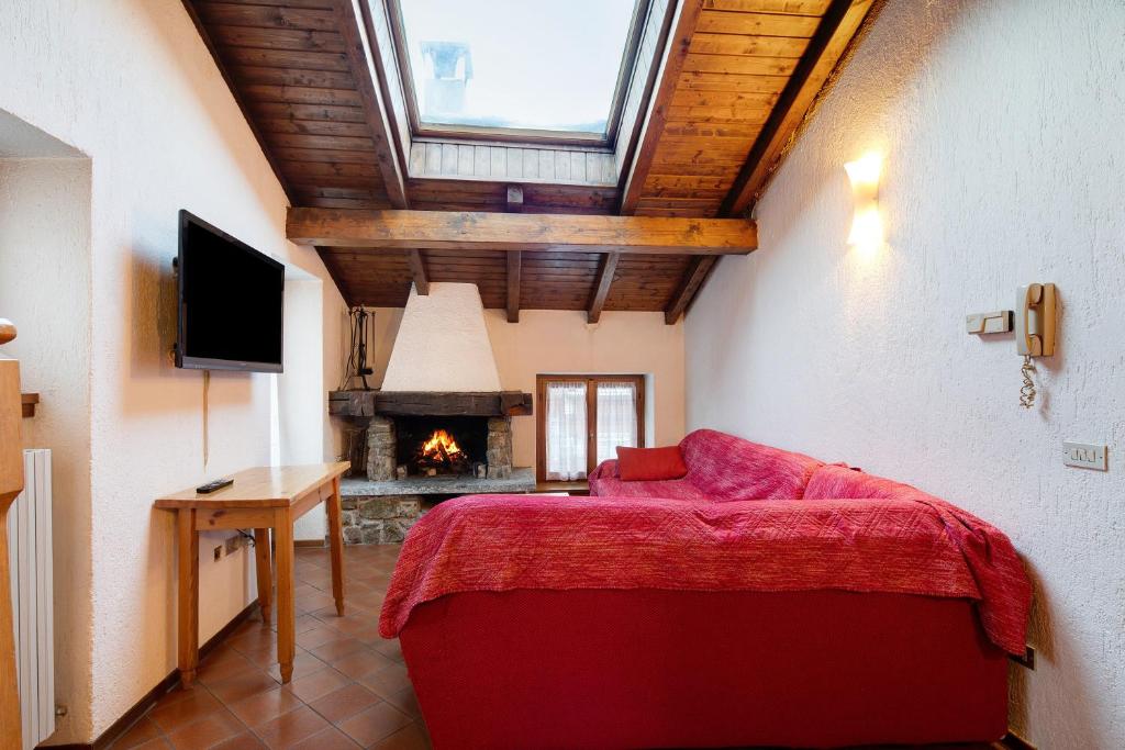 利维尼奥Chalet Meridiana Appartamento 9的一间卧室设有红色的床和壁炉
