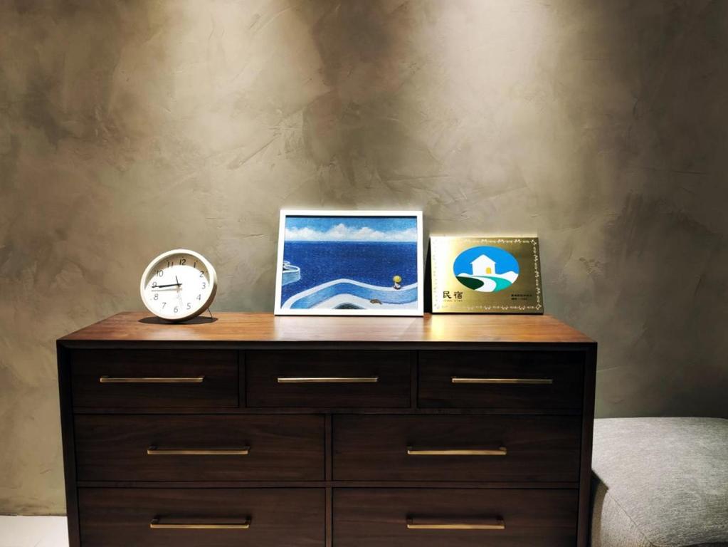 屏东县麟家民宿的一张梳妆台,上面有两张照片和时钟