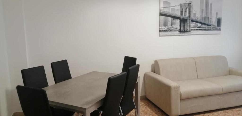 阿斯蒂Casa arcobaleno的带沙发、桌子和椅子的用餐室