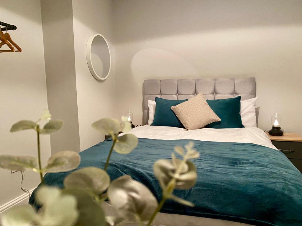 Killingbeck✪ Spacious Luxury 2-bed w/ parking & garden的一间卧室配有一张带蓝色毯子的床