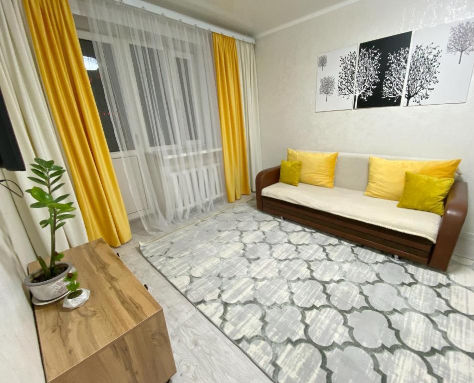 (( Turksib ))Апартаменты на Ахметова 6的客厅配有黄色窗帘和沙发