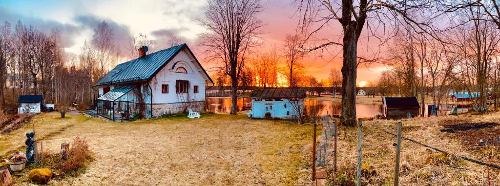 StjärnsundRomantic Spa Villa with Fireplace by the lake的湖畔田野上的一个小房子