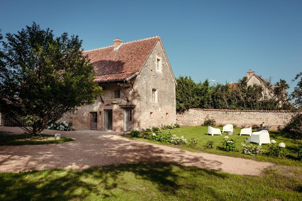 ChapaizeClos des Dames de Lancharre的一座带椅子的老石头建筑,在院子里