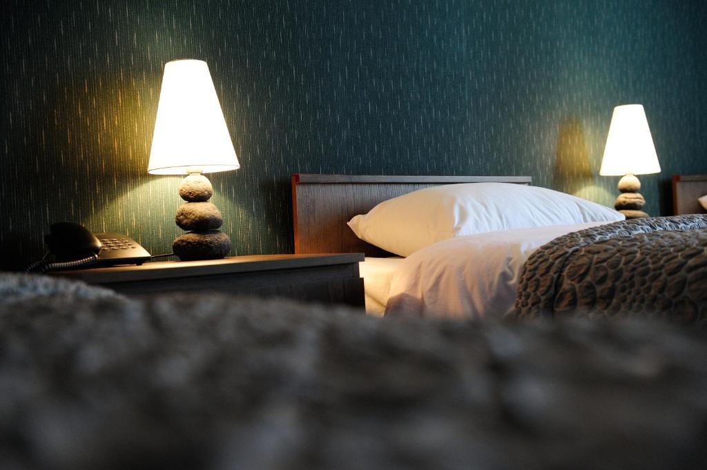 第比利斯达奇酒店的一间卧室配有一张床和两张台灯。