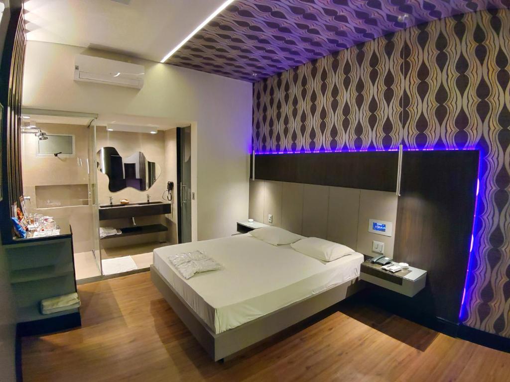 贝洛奥里藏特Motel Dallas的一间卧室设有一张大床和一个紫色的天花板