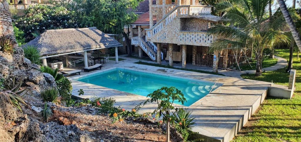 瓦塔穆Marijani Holiday Resort的房屋前的游泳池