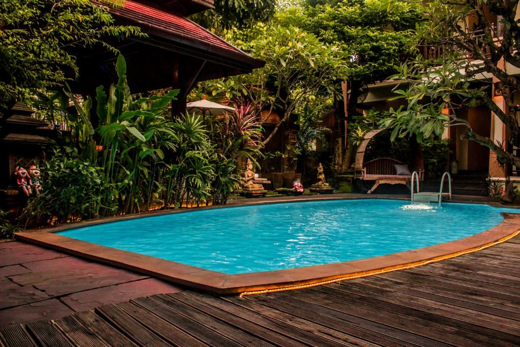 清迈阿玛塔兰纳精品酒店的一个带木甲板的庭院内的游泳池