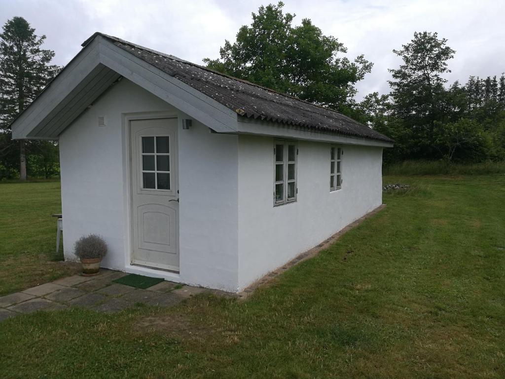 吉弗Hærvejsly - Perfekt familiebase til oplevelse af Sydjylland的院子里有门的小白色棚子