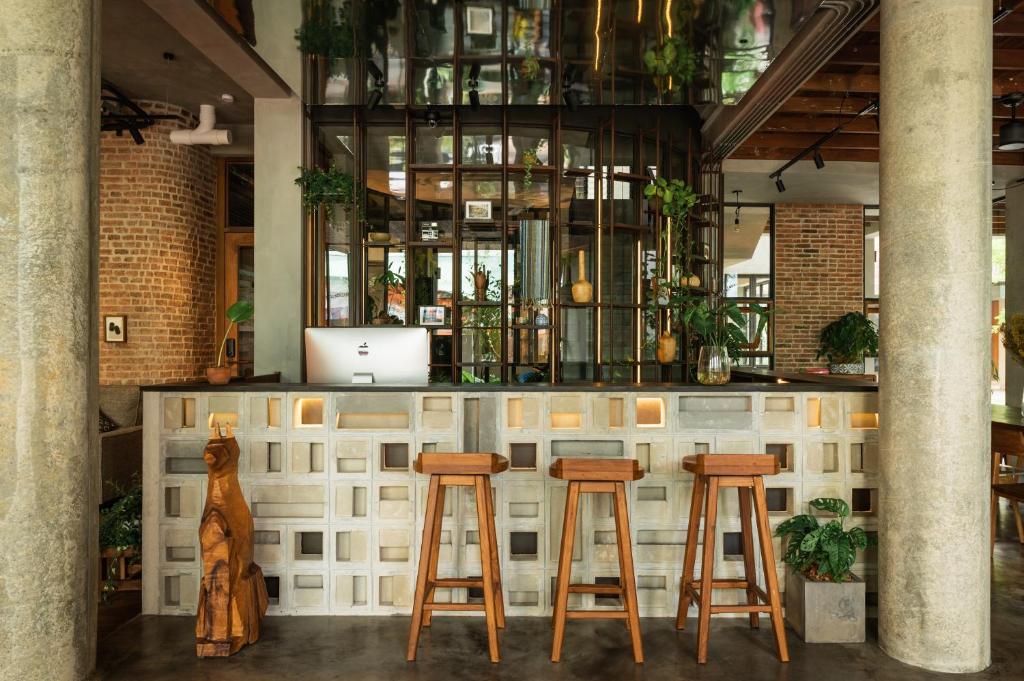 曼谷Tamni的一间酒吧,在一间房间里设有三张木凳