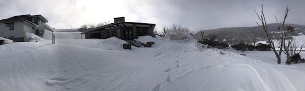 Smiggin HolesThe Lions Lair Lodge的房子前面的一堆雪