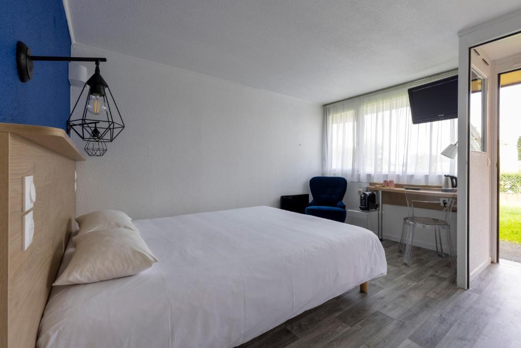 贝尔纳堡Le 2 By Hotel Akena - La Ferté Bernard的一间卧室配有一张床、一张桌子和一把椅子