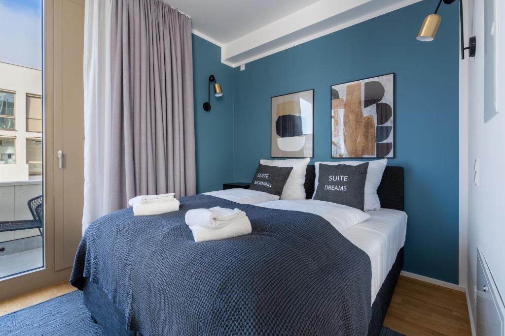 波茨坦limehome Potsdam Annemarie-Wolff-Platz的一间卧室设有两张带蓝色墙壁的床