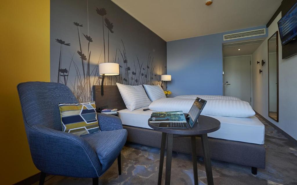 蒂罗尔州霍尔希韦斯特酒店的一间卧室配有一张床和一张桌子上的笔记本电脑