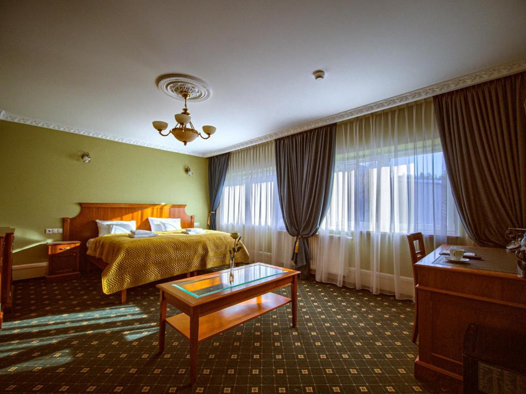 比亚韦斯托克ApartHotel Hubertus的酒店客房配有一张床铺和一张桌子。