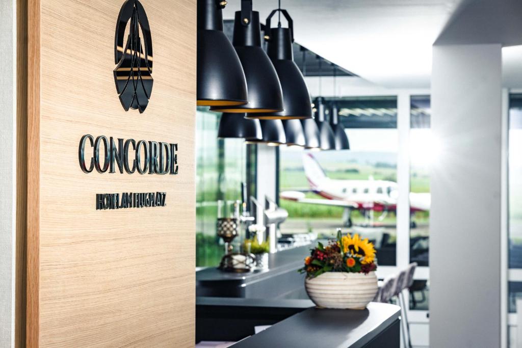 多瑙艾辛根Concorde Hotel am Flugplatz的带有阅读汇合耐力标志的餐厅