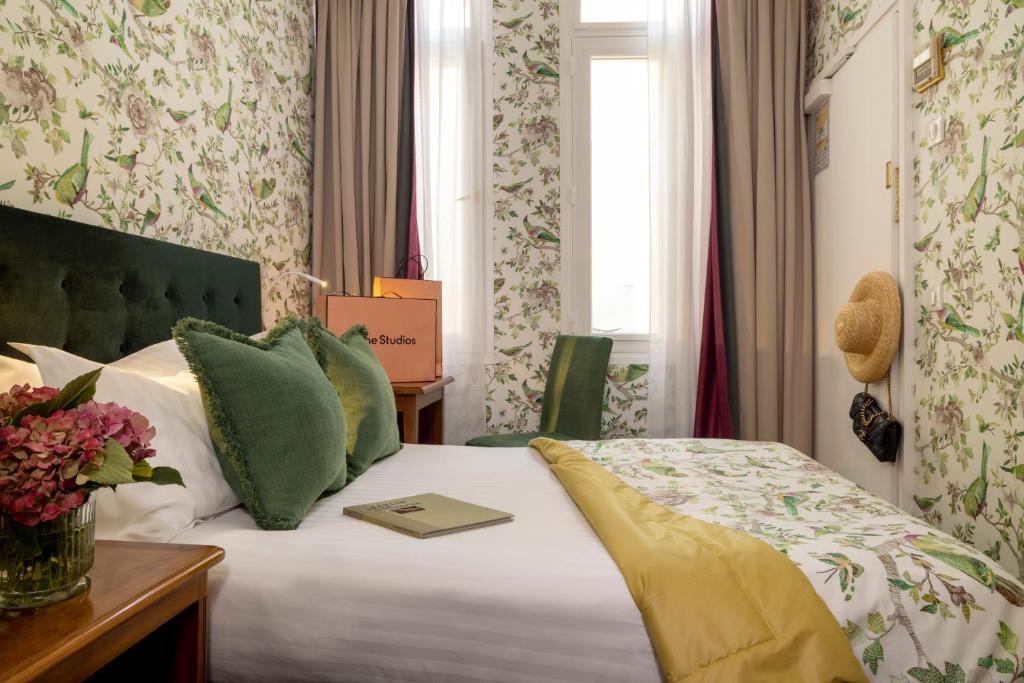 巴黎雷让巴黎酒店的酒店客房,配有一张床铺,上面有一本书
