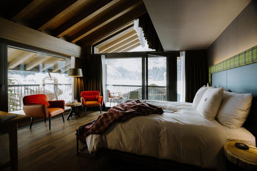 格林德尔瓦尔德Bergwelt Grindelwald - Alpine Design Resort的卧室配有一张床和一张桌子及椅子
