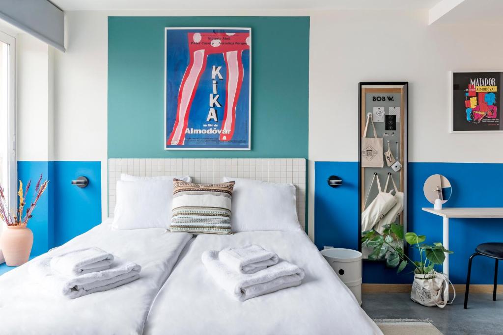 马德里Bob W Chueca的卧室拥有蓝色和白色的墙壁,配有一张床