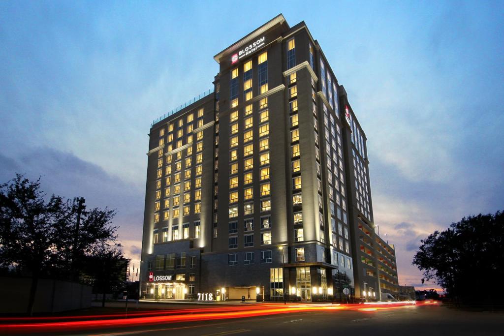 休斯顿Blossom Hotel Houston的一座高大的建筑,晚上有灯