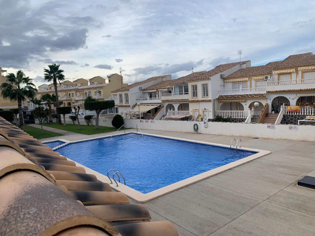 马力诺港Adosado tranquilo con piscina y vistas al mar的部分房屋前设有一个大型游泳池