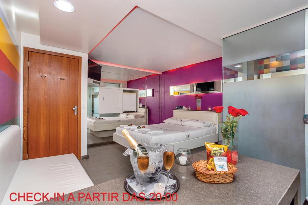 阿雷格里港Motel Porto dos Casais的卧室设有紫色墙壁、一张床和一张桌子