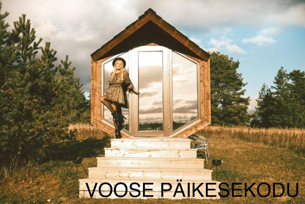 VoseVoose Päikesekodu的一位女士站在楼梯上的一个小房子里
