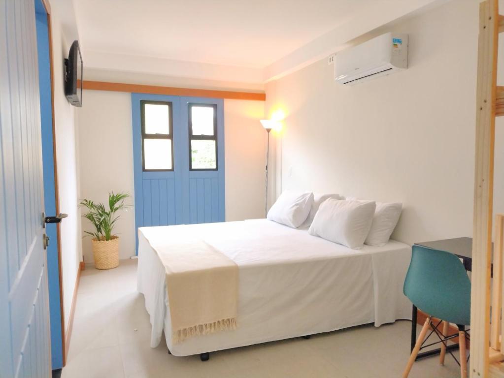 维拉维尔哈Pousada VilaZinha的卧室配有白色的床和蓝色的门