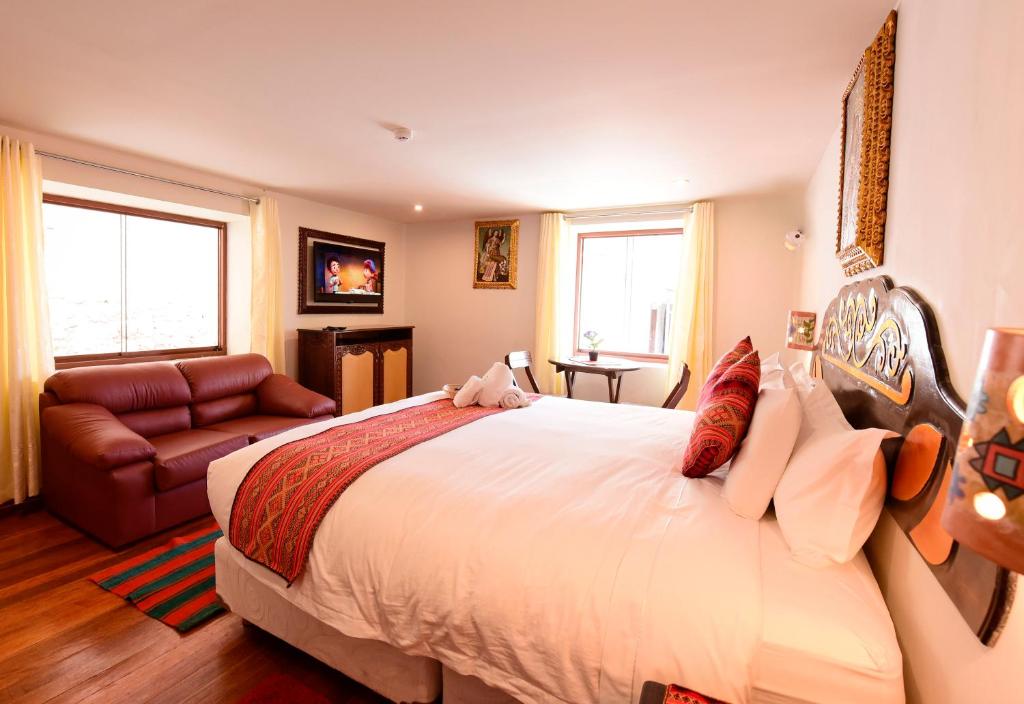 库斯科Hotel Boutique Gold Garden的一间卧室配有一张大床和一张沙发