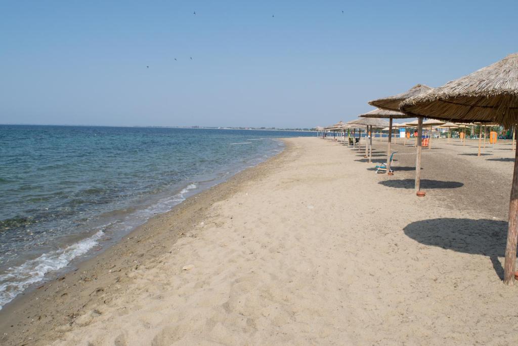 卡利维亚波里吉鲁Mikiverna Houses By Miltiadis的海滩上设有遮阳伞和椅子,还有大海