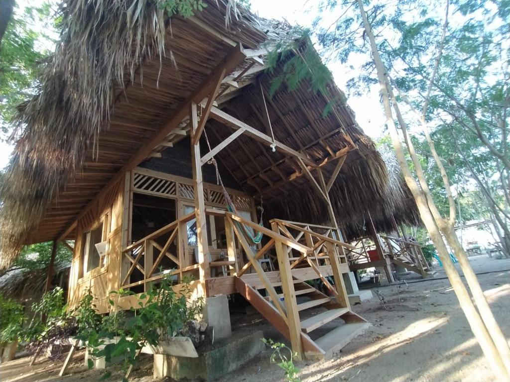 格兰德岛Centro Ubuntu的茅草屋顶的小小屋和楼梯