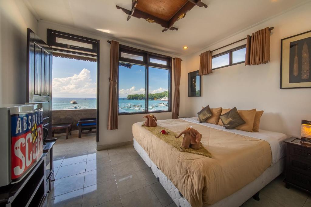 八丹拜完美浮潜巴厘岛潜水度假村的一间卧室设有一张大床,享有海景