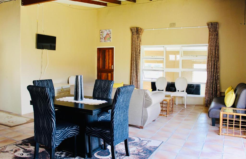 咖啡湾Coffee Bay Lodge的客厅配有桌椅和沙发