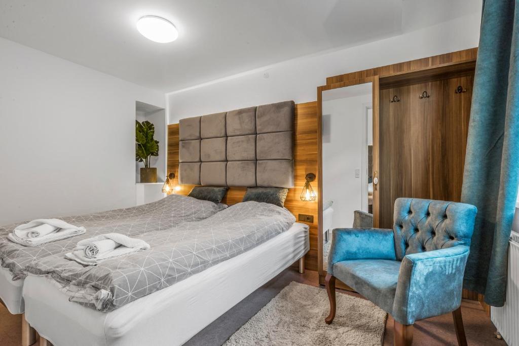 埃斯比约Esbjerg BB hotel的一间卧室配有一张床和一张蓝色椅子