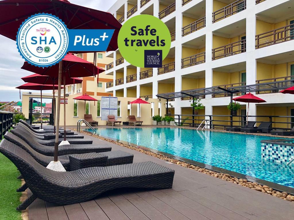 芭堤雅市中心芭提雅黄金海酒店 - SHA Extra Plus的酒店设有带椅子和遮阳伞的游泳池