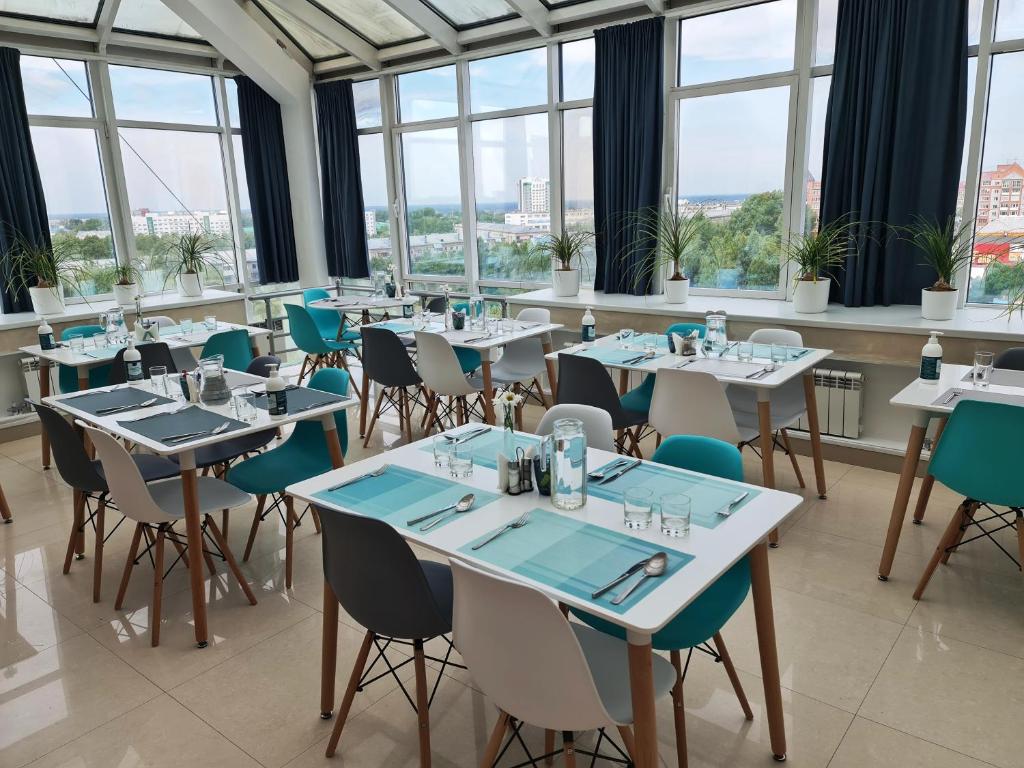 托木斯克斯波特酒店的用餐室设有桌椅和窗户。