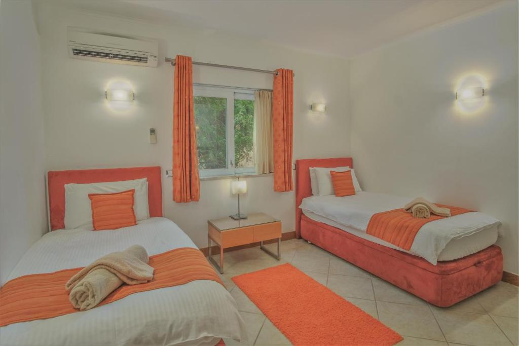 拉戈斯Casa Monte Cristo Apartments - Orange的一间卧室设有两张床和窗户。