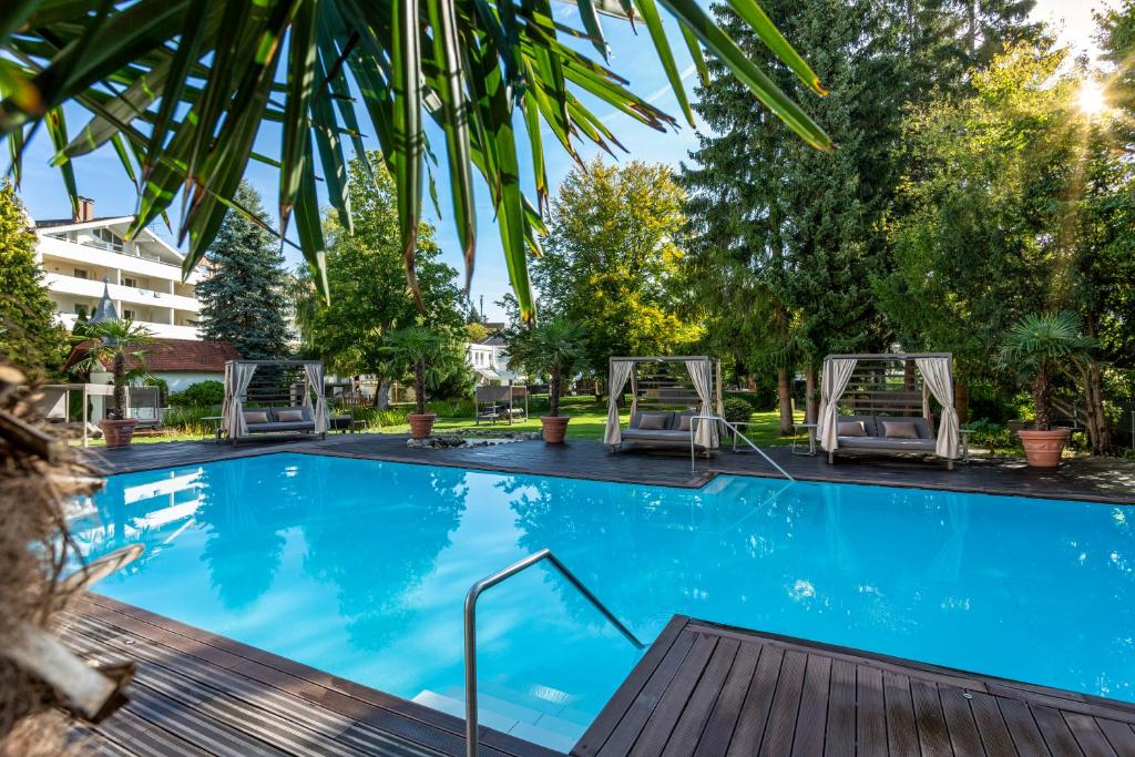 巴特沃里斯霍芬Das Parkhotel的一座带两把椅子和树木的大型游泳池