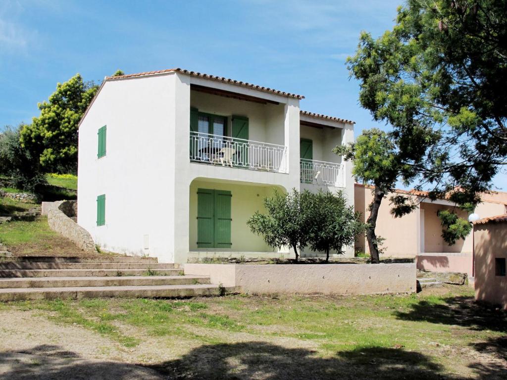 阿尔加约拉Apartment Cala di Sole - ALG131 by Interhome的白色的房子,有树和楼梯