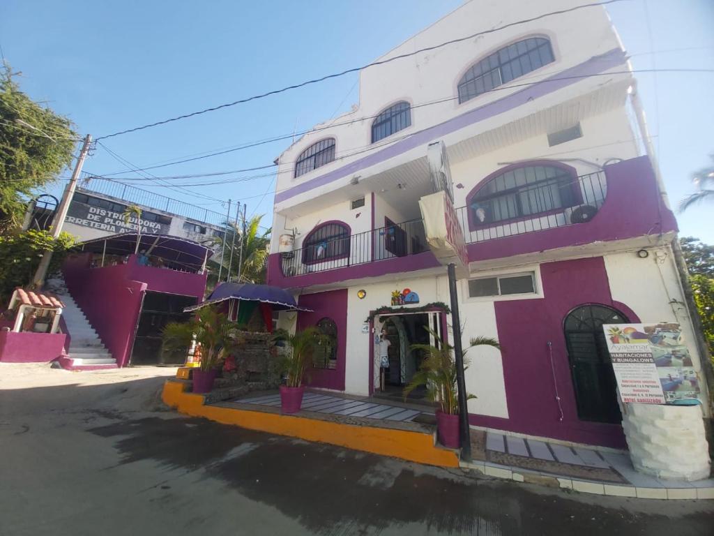 曼萨尼约阿拉亚马尔曼萨尼约酒店的紫色和白色的建筑,设有门廊